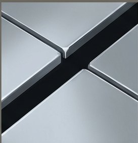 A seamless chrome surface split by a hairline black seam in a precise X.
